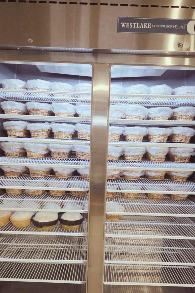 Sourdough loaves cold proofing in a commercial refrigerator during holiday micro bakery prep